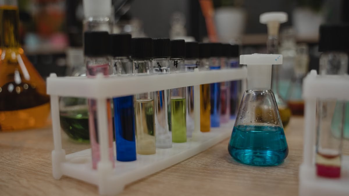 A collection of colorful test tubes and flasks in a chemistry laboratory setting.